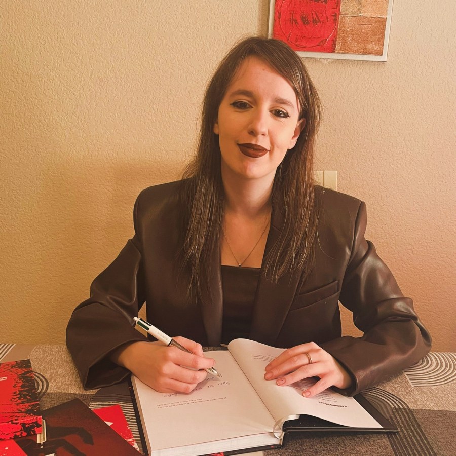 Escritora firmando un libro